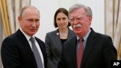 Russian President Vladimir Putin, left, and U.S. National Security Adviser John Bolton shake hands during their meeting in the Kremlin in Moscow, Oct. 23, 2018. 