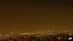 Smoke from a wildfire north of the Greek capital, spreads over Athens, Greece, Aug. 3, 2021. Thousands of people fled their homes north of Athens on Tuesday as a wildfire broke out of the forest and reached residential areas.