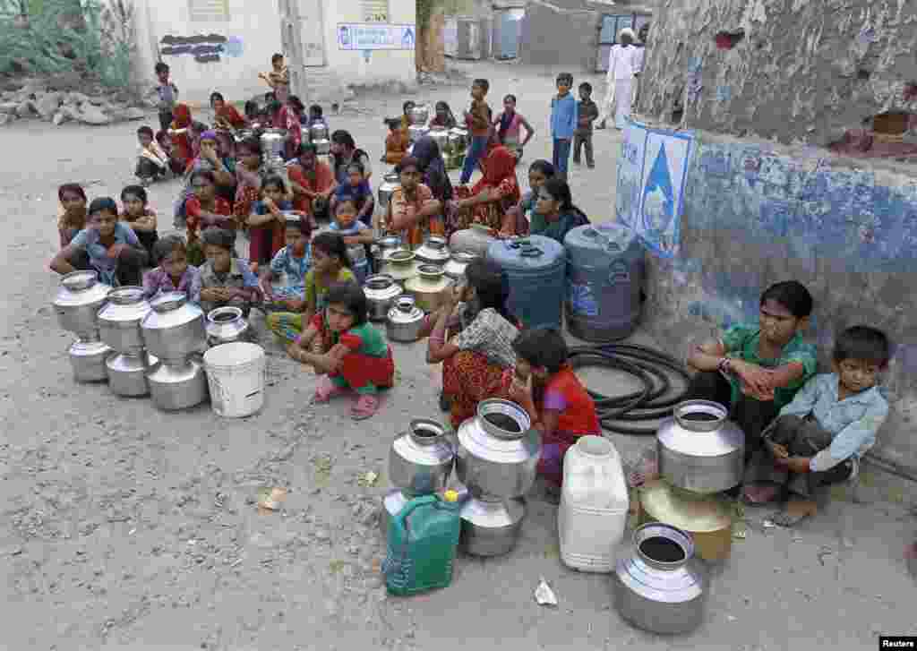 Penduduk desa di India, menunggu dengan wadah mereka untuk mendapatkan jatah air dari pemerintah di desa Padan, negara bagian Gujarat.