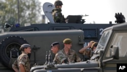British troops stand near their vehicles after crossing the border from Bulgaria in Giurgiu, Romania, June 1, 2017 to take part in the alliance's Noble Jump 2017 exercise.