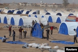 FILE - Workers prepare a tent camp in Khazer west of the Kurdish regional capital Erbil, Iraq, Oct. 11, 2016, for people expected to flee Mosul.