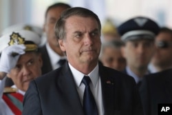 FILE - Brazil's President Jair Bolsonaro arrives for the inauguration ceremony of his new naval commander, Ilques Barbosa Jr., at the Naval Club in Brasilia, Jan. 9, 2019.