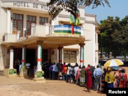 FILE - Voters line up to cast their ballots at a polling station set up at the Hotel De Ville during the presidential election in Bangui, the capital of Central African Republic, Dec. 30, 2015.
