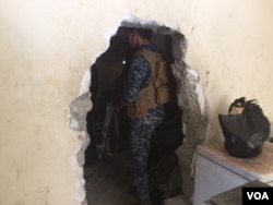 Across West Mosul, homes have holes in the walls that IS militants forced families to make so they could travel from house to house without being seen by airstrikes. Soldiers now use them in the areas they've captured to avoid IS snipers. June 23, 2017, in Mosul, Iraq. (H. Murdock/VOA)