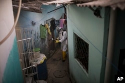 In this Jan. 26, 2016 photo, a municipal worker sprays insecticide to combat the Aedes aegypti mosquitoes that transmits the Zika virus, at the Imbiribeira neighborhood in Recife, Pernambuco state, Brazil.