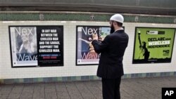 Sayrus MakGoldrik metro bekatidagi plakatni suratga olmoqda