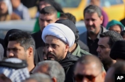FILE - Qais al-Khazali, center, the leader of the Shi'ite group Asa'ib Ahl al-Haq, or League of the Righteous, attends a funeral procession of six members of his militia who were killed in Tikrit fighting Islamic militants.