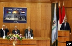 The Damascus-based leader of Hamas Khaled Mashaal, right, gives a speech as Palestinian President Mahmoud Abbas, left, sits next to Egypt's intelligence chief Murad Mewafi, 2nd left, during the reconciliation meeting in Cairo, Egypt, May 4, 2011