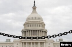 FILE - The dome of the U.S. Capitol is seen beyond a chain fence during the partial government shutdown in Washington, Jan. 8, 2019.
