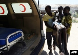 FILE - An illegal migrant is carried to an ambulance after he was rescued by the Libyan coast guard when the boat he was on sank off the coastal town of Garabulli, 60 kilometers east of Tripoli, Sept. 15, 2014.