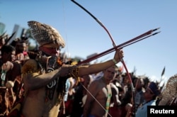 A member of an indigenous tribe holds a bow and arrows during a protest to defend land and cultural rights that indigenous people say are threatened by the government of Brazil's President Jair Bolsonaro, in Brasilia, April 26,