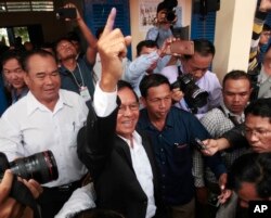 Opposition Cambodia National Rescue Party President Kem Sokha shows his inked finger after voting in local elections in Chak Angre Leu on the outskirts of Phnom Penh, June 4, 2017.