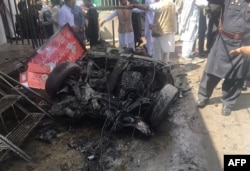 FILE - Pakistani security officials and residents gather at the site of a powerful explosion at a market in Parachinar, capital of the Kurram tribal district, March 31, 2017.
