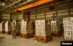 U.S. Army parachute riggers with the 11th Quartermaster Company, 264th Combat Sustainment Support Battalion, 82nd Sustainment Brigade, palletize meals for a humanitarian airdrop over Iraq at an undisclosed site in Southwest Asia, Aug. 7, 2014.