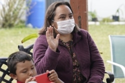 Ofelia Aguilar raises her hand as she watches the swearing-in ceremony for Joe Biden as the 46th President of the United States, Wednesday, Jan. 20, 2021 in Homestead, Fla. (AP Photo/Marta Lavandier)