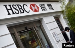 FILE - A worker uses an ATM at a branch of HSBC in Chinatown in central London, June 9, 2015.
