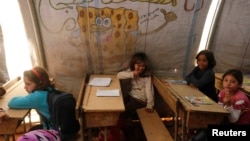 FILE - Children attend a class inside a makeshift school in the Bab Al-Salam refugee camp in Azaz, Syria, Oct. 27, 2014.