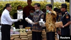 FILE - Indonesian President Joko Widodo (C) and other officials prepare to destroy illegal narcotics during an event in Jakarta, Indonesia, Dec. 6, 2016.