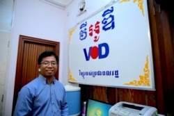 លោក ណុប វី ប្រធាន​ផ្នែក​ប្រព័ន្ធ​ផ្សព្វផ្សាយ​នៃ​មជ្ឈមណ្ឌល​កម្ពុជា​ដើម្បី​ប្រព័ន្ធ​ផ្សព្វផ្សាយ​ឯករាជ្យ​ CCIM ឈរ​ក្បែរ​ស្លាក​សញ្ញា​វិទ្យ​វីអូឌី ដែល​មាន​សរសេរ​ពាក្យ​«វិទ្យុ​របស់​ប្រជាពលរដ្ឋ» នៅ​ក្នុង​បន្ទប់​គ្រប់គ្រង​ការផ្សាយ​មួយ​ក្នុង​ការិយាល័យ​វីអូឌី​ក្នុង​រាជធានី​ភ្នំពេញ​កាល​ពី​ថ្ងៃ​ពុធ ទី​១១ ខែ​កញ្ញា​ ឆ្នាំ​២០១៩។ (សឹង សុផាត/VOA)