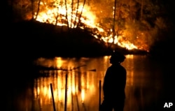 A firefighter stands near a wildfire in Middletown, California, Sept. 13, 2015.