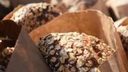 Bags of freshly-baked bread covered in oat flakes