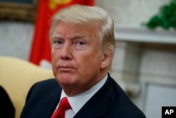 President Donald Trump listens to a question from a reporter during a meeting with Nigerian President Muhammadu Buhari in the Oval Office of the White House, April 30, 2018, in Washington.