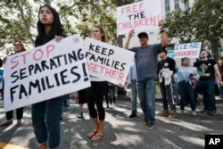 Protesters carry signs and chant slogans in front of Federal Courthouse in Los Angeles, June 26, 2018.