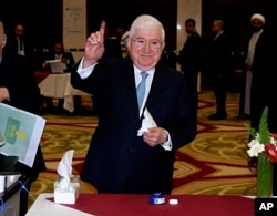 FILE - Then-Iraqi President Fuad Masum shows his ink-stained finger after casting his vote in the country's parliamentary elections in the heavily fortified Green Zone in Baghdad, Iraq, May 12, 2018.
