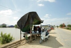 ពលរដ្ឋ​ដែល​ផ្ទះ​ត្រូវបាន​ជន់លិច ផ្លាស់ទី​មក​រស់នៅ​លើ​ផ្លូវ​ដែល​ជា​កន្លែង​ទីទួល​សុវត្ថិភាព​ជា​បណ្តោះ​អាសន្ន នៅ​សង្កាត់​សាក់សំពៅ ខណ្ឌដង្កោ រាជធានី​ភ្នំពេញ នៅ​ថ្ងៃទី២៦ ខែតុលា ឆ្នាំ២០២១។ (លាស់ លីបលីប/វីអូអេ)