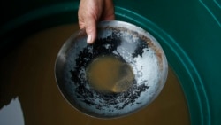 An illegal miner shows gold extracted from the Madeira river, a tributary of the Amazon, aboard a dredging barge in Autazes, Amazonas state, Brazil, Nov. 25, 2021.