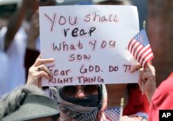 A demonstrator holds a sign during a protest outside the U.S. Border Patrol Central Processing Center, in McAllen, Texas, June 23, 2018.
