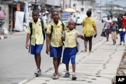 FILE - School children walk in the street in Lagos, Nigeria, June 17, 2014.