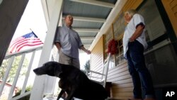 FILE - Virginia voter Harry Donahue talking to his wife Nancy on the front porch of their farmhouse, built in the 1700's, in Farmville, Va.