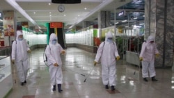 FILE - Staff of the Pyongyang Department Store No. 1 disinfect the store to help curb the spread of the coronavirus before it opens in Pyongyang, North Korea, Dec. 28, 2020.