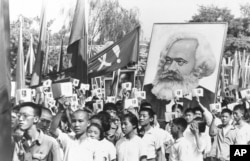 FILE - In this file photo taken Sept. 14, 1966, youths are seen at a rally during the height of the Red Guard upheaval waving copies of the collected writings of Communist Party Chairman Mao Zedong, often referred to as Mao's Little Red Book and carrying a poster of Karl Marx.