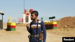 An officer of the Syrian Kurdish Democratic Union Party (PYD) stands guard near the Syrian-Iraq border, October 31, 2012.