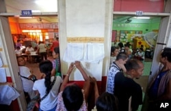 Filipinos check for their names on registration lists to vote as polling stations prepare to close at a school in suburban Manila, Philippines on Monday May 9, 2016.