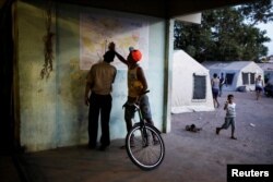 Venezuelans look at a map of the city of Boa Vista outside a gym which has turned into a shelter for Venezuelans in Boa Vista, Brazil, Nov. 18, 2017.