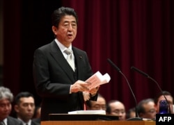 FILE - Japan's Prime Minister Shinzo Abe delivers a speech during the graduation ceremony of the National Defense Academy in Yokosuka, Kanagawa prefecture, Japan, March 18, 2018.