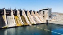 FILE - An aerial view of the closed sluice gates are seen at the 1973 Tabqa Dam along the Euphrates River in Raqqa province in eastern Syria, July 26, 2021. Aid groups are warning of a looming humanitarian disaster in northeast Syria, where plummeting water levels at hydroelectric dams are threatening water and power cutoffs for millions.