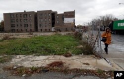 A pedestrian walks past an abandoned lot on a street on the South Side of Chicago that is part of the 6th Police District. Officers there marked a milestone this fall when they recovered their 1,000th gun for the year.