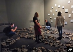 In this photo taken on Sunday, Feb. 17, 2019, visitors attend an exhibition by Russian artist Pavel Otdelnov in Moscow, Russia. (AP Photo/Ivan Kochkarev)