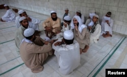 FILE - Pakistani religious students and teachers attend a discussion session at the Ganj Madrassa in Peshawar.