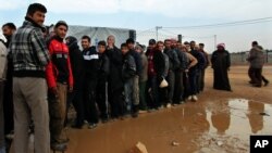 Newly arrived Syrian refugees wait their turn to receive mattresses, blankets and other supplies, and to be assigned to tents, at the Zaatari Syrian refugees camp in Mafraq, near the Syrian border with Jordan, Jan. 28, 2013.