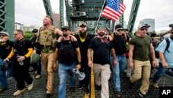 Members of the Proud Boys and other right-wing demonstrators march during an "End Domestic Terrorism" rally in Portland, Oregon, on Aug. 17, 2019. The group includes Proud Boys Chairman Enrique Tarrio, holding megaphone.