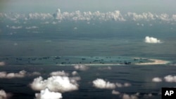 FILE - An aerial photo taken May 11, 2015 through a glass window of a military plane shows China's alleged on-going reclamation of Mischief Reef in the Spratly Islands in the South China Sea. 