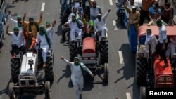 Para petani dengan traktor meneriakkan slogan-slogan ketika mereka tiba untuk memblokir perbatasan Delhi-Uttar Pradesh selama protes terhadap tagihan pertanian yang disahkan oleh parlemen India, di Noida, India, 25 September 2020. (Foto: REUTERS/Danish Siddiqui)