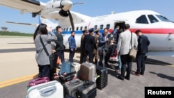 Wartawan Korea Selatan, yang akan meliput ke fasilitas uji coba nuklir Punggye-ri, tiba di bandara Kalma, Wonsan, Korea Utara, 23 Mei 2018.