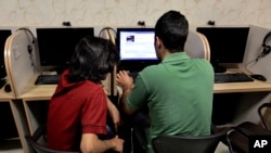 FILE - An Iranian man uses a computer at an Internet cafe, in Tehran, May 27, 2013. 
