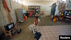 File- A boy watches TV in his family's shelter at a school in the southern Yemeni port city of Aden.